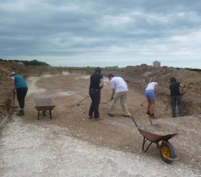The team clean he surface  of the archaeological features